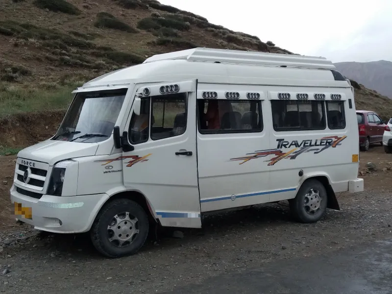 White Force Tempo Traveller parked by a mountain road