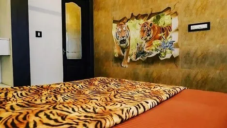 Bedroom with a tiger-print bedspread and a tiger mural on the wall