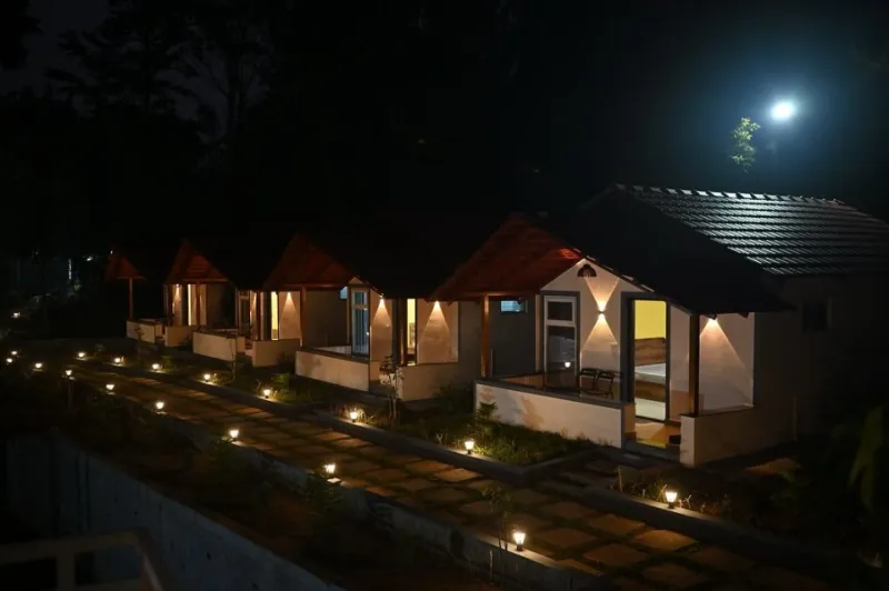 Row of cottages along a lamp-lit stone path at night