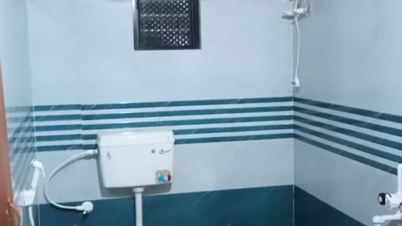 Bathroom with striped blue tiles and a toilet