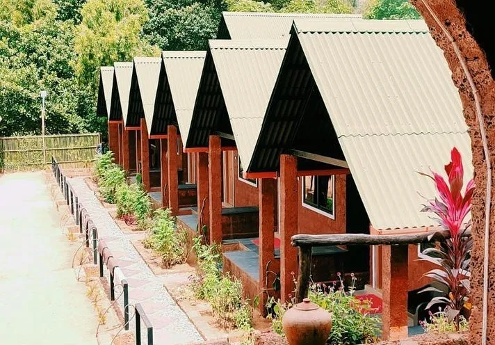 Row of laterite-stone cottages with sloping roofs and a garden path