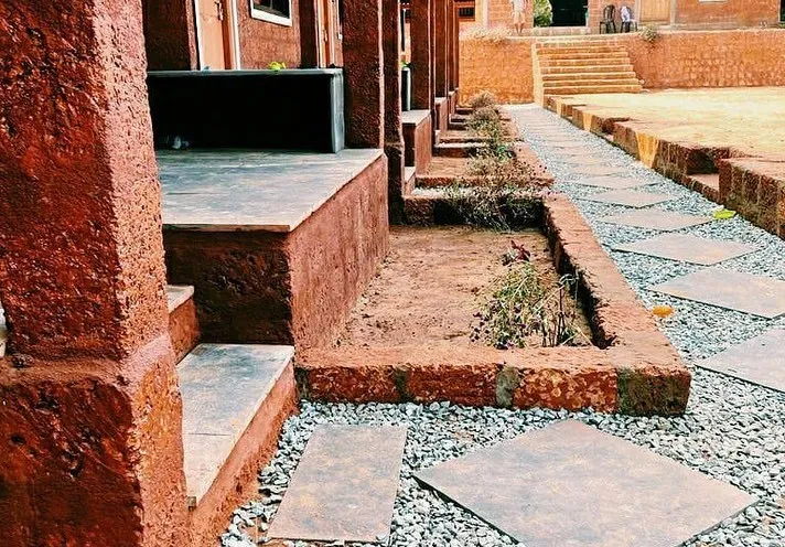 Laterite stone verandahs and a stepping-stone path between the cottages