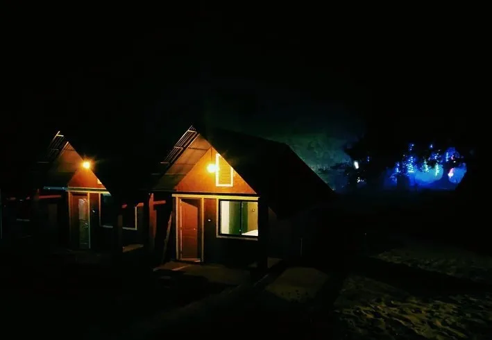 Cottages lit up at night by the beach