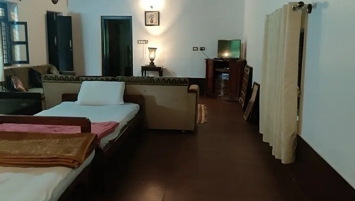 Spacious hall with beds, sofas and a television