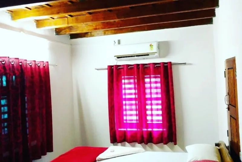 Air-conditioned room with a wooden-beamed ceiling and red curtains
