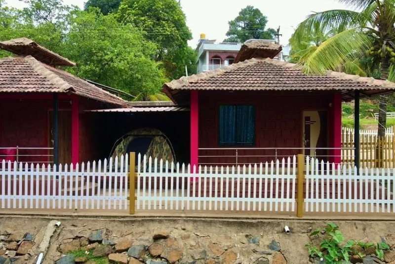 Laterite cottages with tiled roofs and a white picket fence