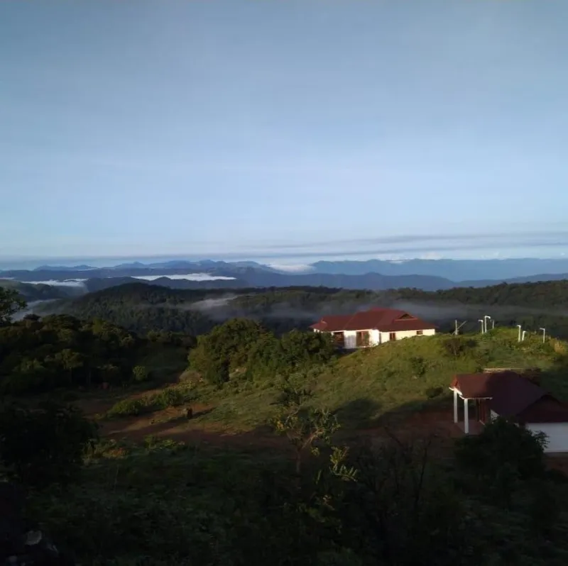 Hilltop cottages above forested valleys and morning mist