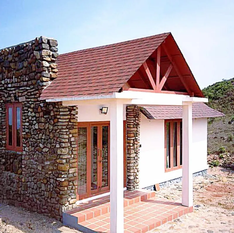 Stone and plaster cottage with a gabled roof and a tiled porch
